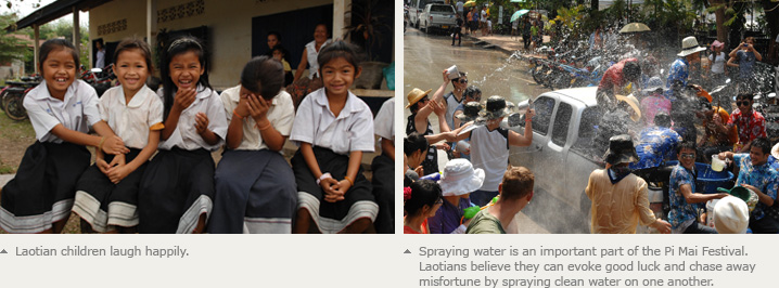 Laotian children laugh happily. Spraying water is an important part of the Pi Mai Festival. Laotians believe they can evoke good luck and chase away misfortune by spraying clean water on one another. 