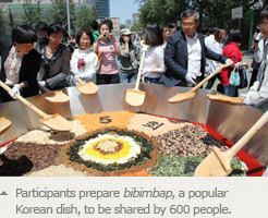 Participants prepare bibimbap, a popular Korean dish, to be shared by 600 people.