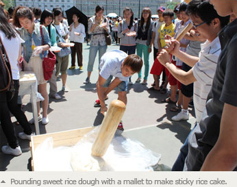 Pounding sweet rice dough with a mallet to make sticky rice cake.